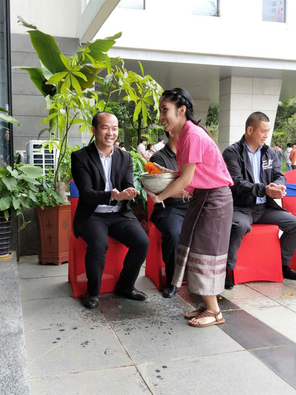 老撾駐廣西留學(xué)生代表將浸有花瓣的香水灑客人的手上，表示對(duì)嘉賓的美好祝福（圖一）